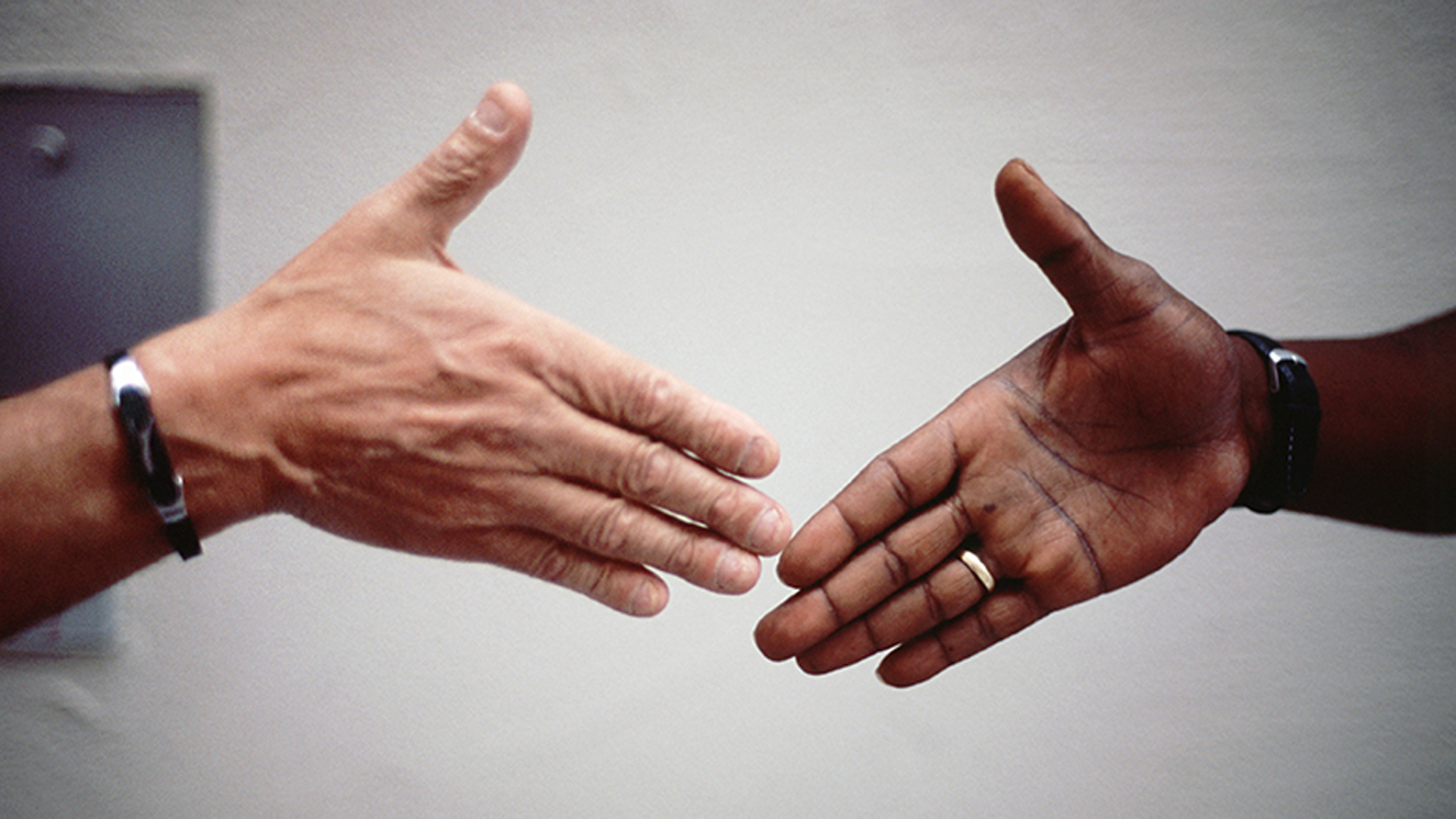 Bewegen sich aufeinander zu: weisse Hand und farbige Hand